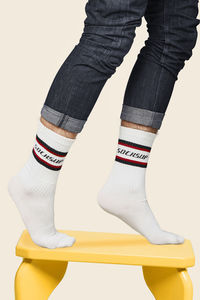 Low section of person standing against white background