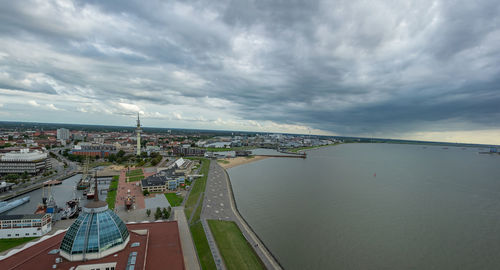 High angle view of city by sea against sky