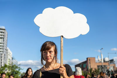 Portrait of smiling woman against blue sky