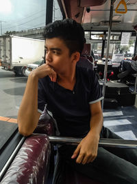 Young man looking away while sitting in car