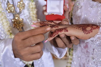 Midsection of couple holding hands