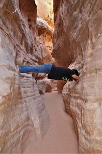 Low angle view of young woman standing on cliff