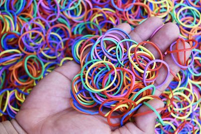 Cropped hand of woman holding multi colored rubber bands