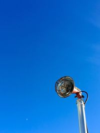 Low angle view of electric lamp against clear blue sky