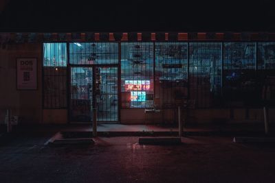 Empty illuminated room with building in background at night
