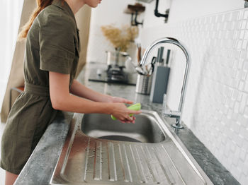 Low section of woman standing in kitchen