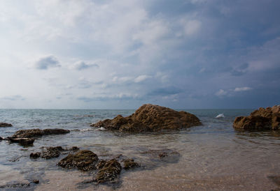 Scenic view of rocks on beach against sky
