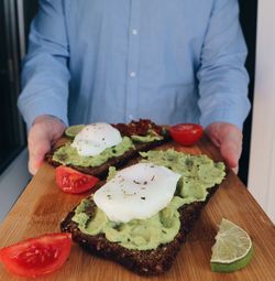 Midsection of man holding breakfast on serving tray