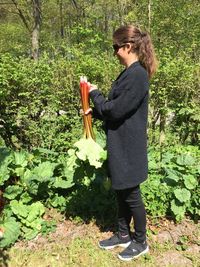 Full length of woman standing by plants