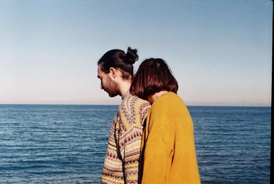 Friends enjoying at sea against clear sky