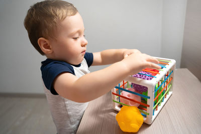 A cute toddler boy is playing a game with sensory colorful balls. sensory and tactile activities.