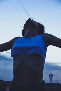 Midsection of man standing against blue sky