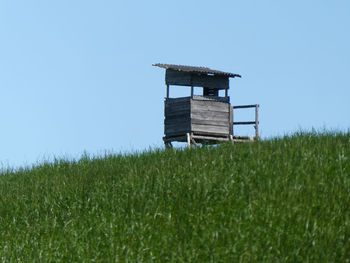 Lifeguard hut on field against clear sky