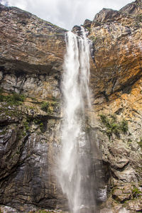 Low angle view of waterfall on rocks