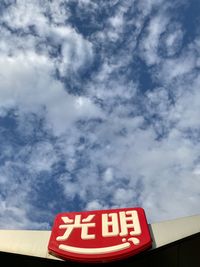 Low angle view of information sign against sky