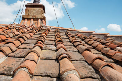 Low angle view of roof tiles against sky