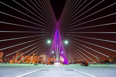 Illuminated bridge in city against sky at night