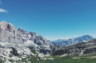 Scenic view of mountains against blue sky