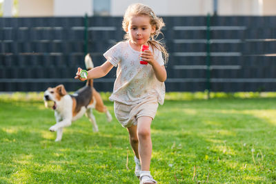 Side view of young woman with dog on field