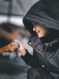 Close-up portrait of woman holding camera in snow