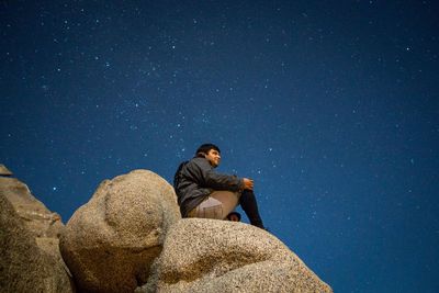 Man on rock formation at night