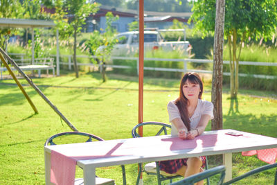 Young woman sitting on swing at park