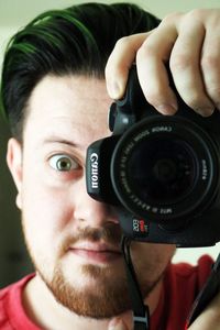 Close-up of young woman holding camera