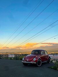 Cars on road against sky during sunset