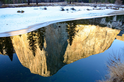 Reflection of snow in lake against sky