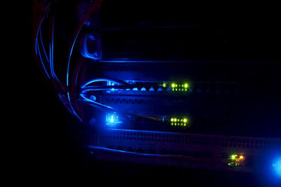 Close-up of illuminated lighting equipment against black background