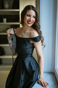 Smiling young woman standing at home