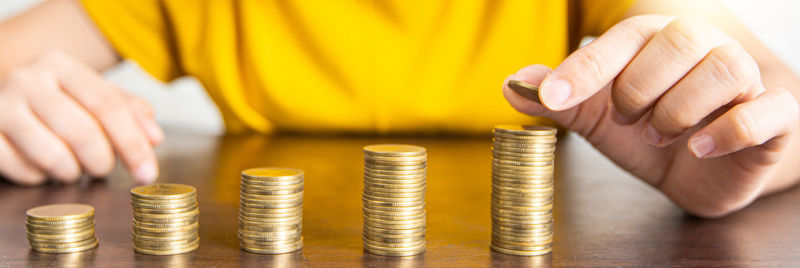 Cropped image of hand holding coin stack