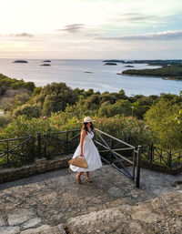 Woman looking at sea against sky