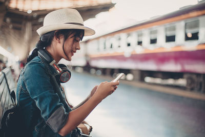 Side view of young woman using mobile phone