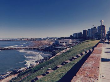 Panoramic view of sea and buildings against clear blue sky