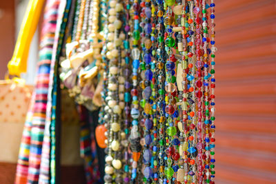 Close-up of colorful beads hanging at market for sale