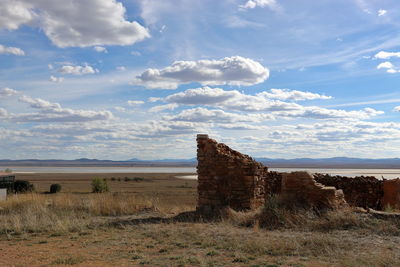 Abandoned building on field against sky