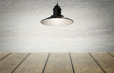 Illuminated light bulb hanging on wall