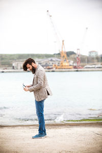 Full length side view hipster standing on pier