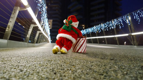 Santa claus toy on illuminated bridge during christmas