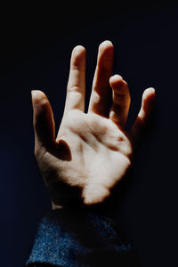 Close-up of human hand against black background