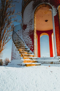 Low angle view of snow on building steps during winter