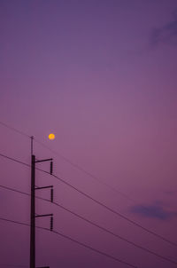 Low angle view of silhouette cables against sky during sunset