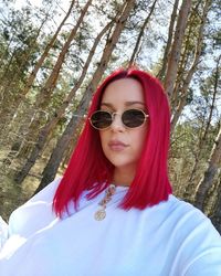 Portrait of beautiful woman with sunglasses against trees