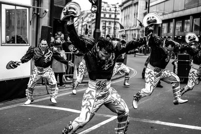 Men performing on city street in festival