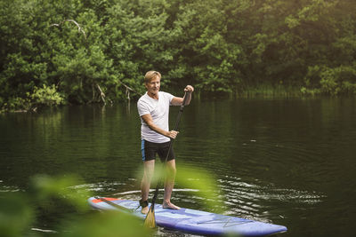 Senior man paddleboarding in sea during sup course