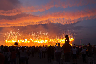 Rear view of people against firework