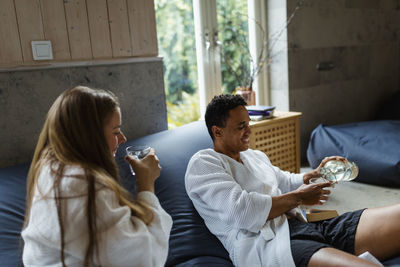 Young woman using mobile phone while sitting at home