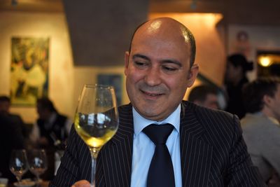 Close-up of businessman having wine at restaurant