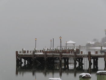 Pier over sea against sky during winter